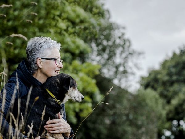 Woman and her dog looking out over a lake